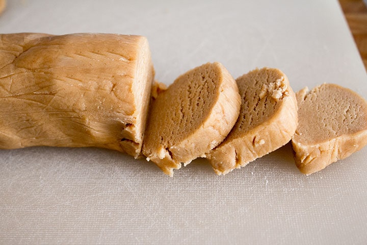 The chilled dough shaped into a log shape with three slices cut out of it