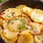 Crispy Garlic Roasted Potatoes in the pan with parsley scattered over it