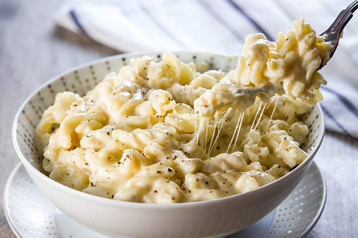 A fork digging into a big bowl of Homemade Creamy Mac and Cheese