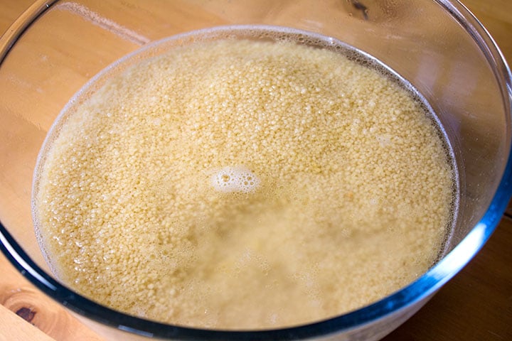 A bowl of couscous covered in water.