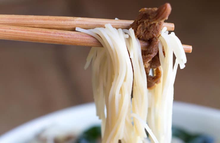 A close up noodles on chopsticks