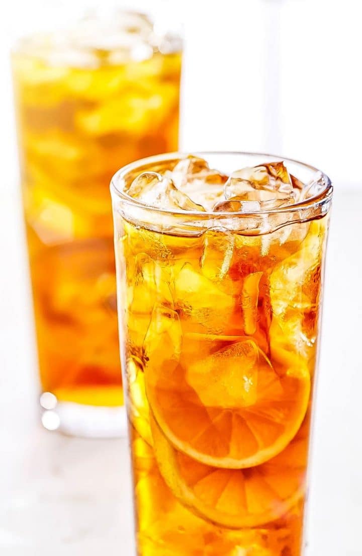 Two tall Glasses of Sweet Lemon Iced Tea with lots of ice and lemon slices
