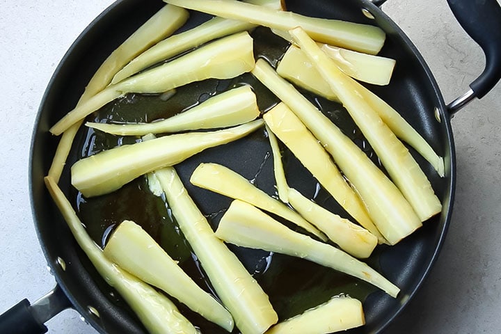 The parsnips in a pan drizzled with honey, butter and maple syrup