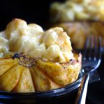 A close up of cheesy pasta stuffed squash