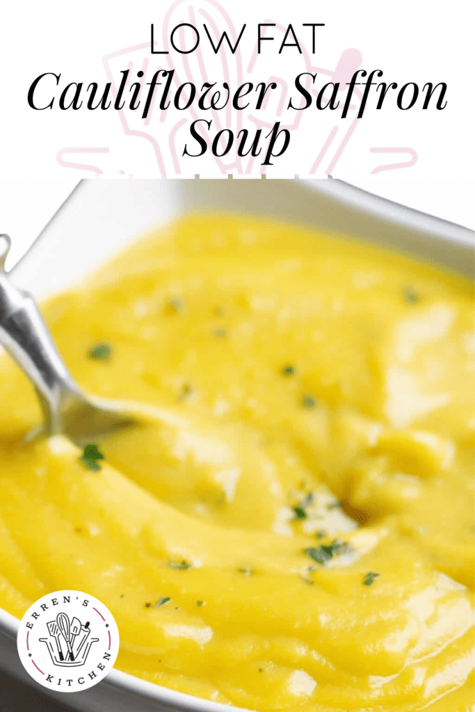 A picture of the thick and creamy yellow saffron cauliflower soup in a bowl with a spoon ready to be served and sprinkled with parsley.