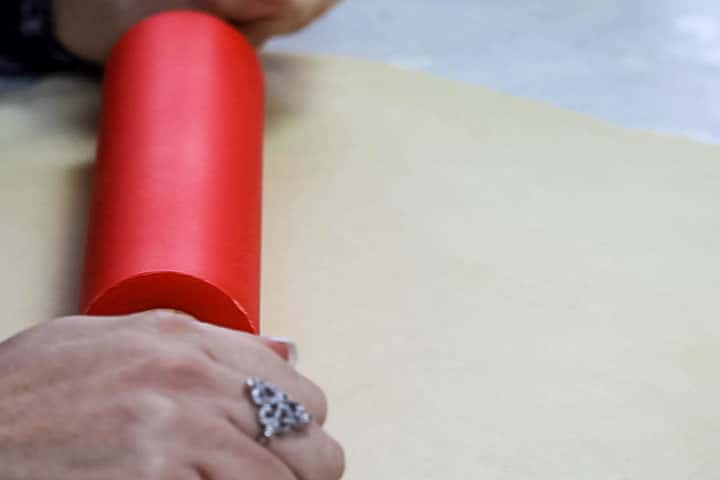 The dough being rolled out with a rolling pin