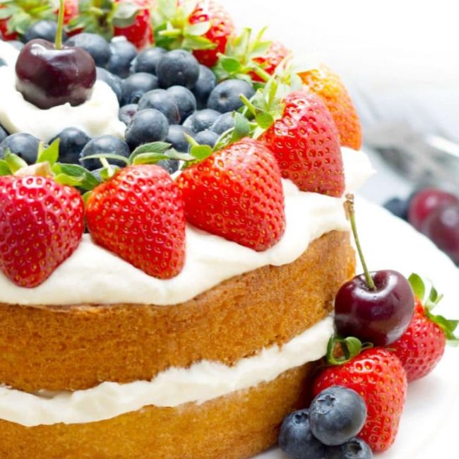 Vanilla Cream Sponge Cake topped with whipped cream and fresh berries