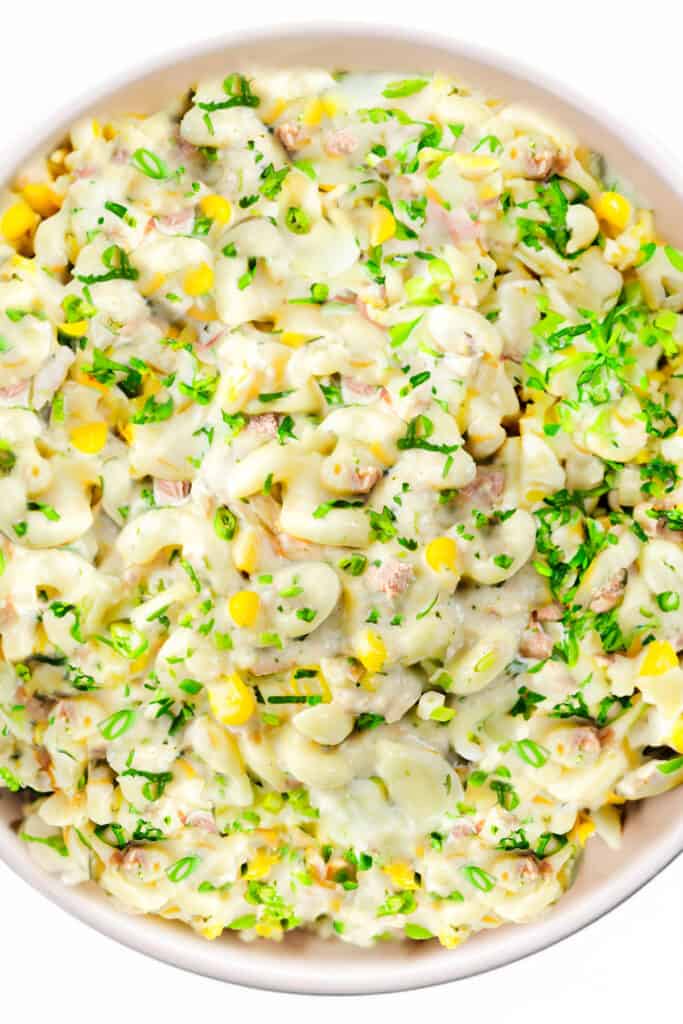 an overhead, close up shot of a bowl of tuna pasta salad coated in the dressing.