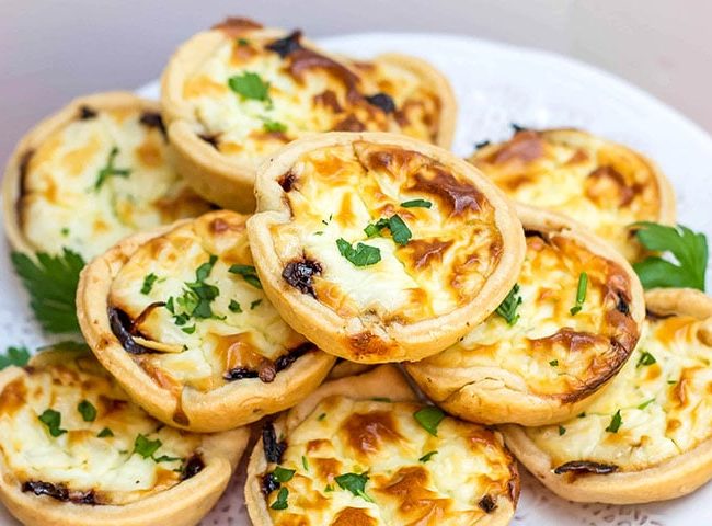 Feta and Caramelized Onion Tarts piled high on a plate