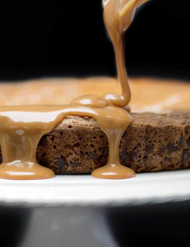 Caramel being poured onto Chocolate Chip Caramel Cake