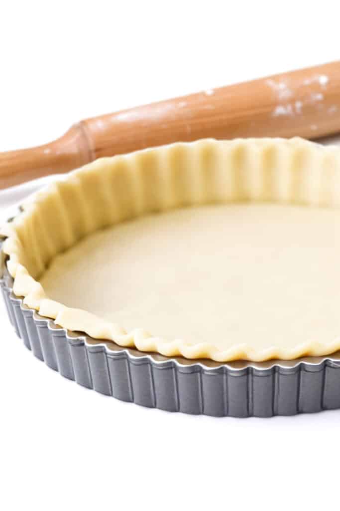 a pie pan with pie crust dough pressed into it.