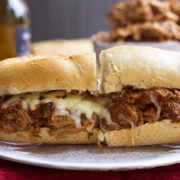 An Italian pulled pork sandwich on a plate cut in half