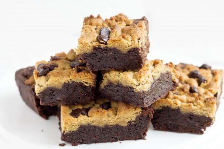 Peanut Butter Chocolate Fudge Brownies piled high on top of each other on a serving dish 