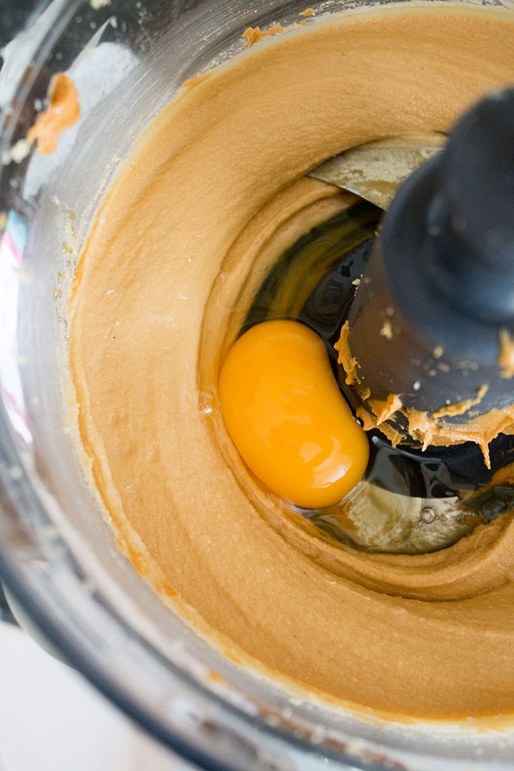 An egg being added to the peanut butter cookie dough