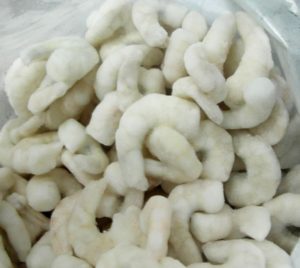 A close up view of a open bag of frozen shrimp