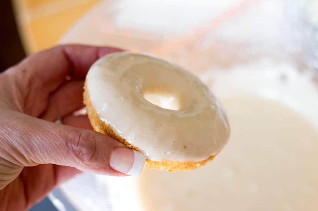 The baked vanilla doughnut wet with icing just after being dipped.