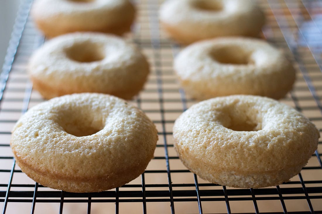 6 Baked Vanilla Doughnuts on a cooling rack