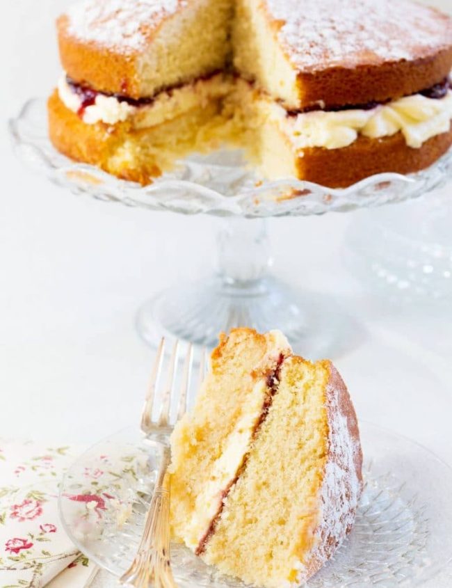 Victoria Sponge Cake filled with buttercream and strawberry jam on a cake platter