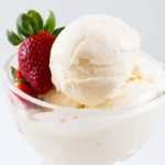 dessert bowl filled with ice cream and a strawberry