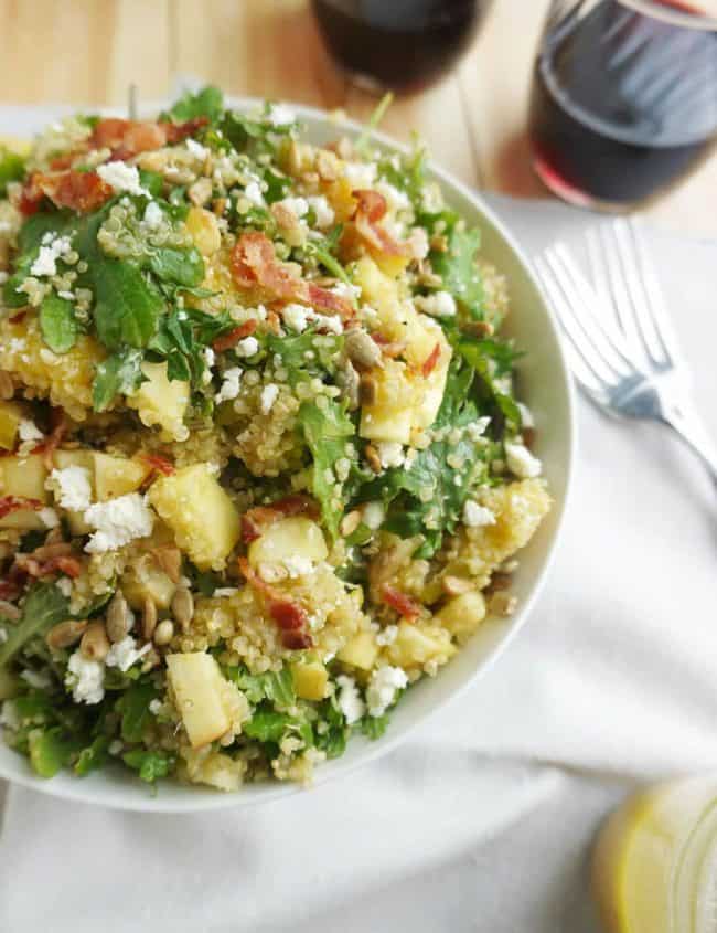 Bacon Quinoa Salad with Lemon Dijon Dressing piled high in a bowl with a fork next to it