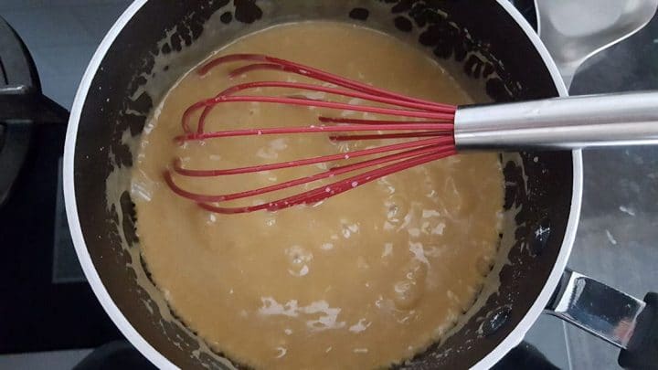 Condensed milk added to the sugar and butter cooking in a pot