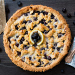 Blueberry Pie just got a sweet and lemony makeover with this recipe for Blueberry Lemon Shortbread Tart. This tart has a buttery, lemon infused, melt in your mouth shortbread base with a luscious, sweet blueberry filling. To top it off, a crumble of the lemon shortbread. It's a summer dessert you won't soon forget.