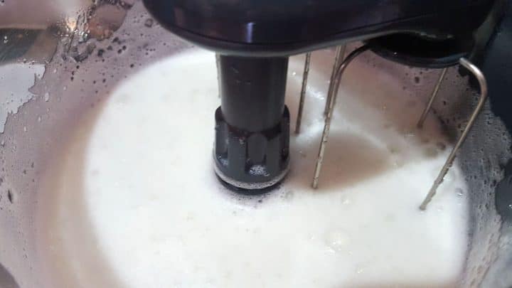 egg whites being whipped in a mixing bowl