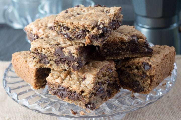 Chocolate Chip Spiced Oat Bars stacked high on a crystal cake stand