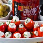 A platter with the stuffed peppers and a jar of peppers in the background.