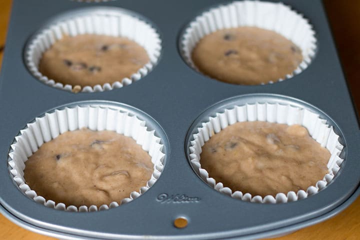 the batter added to the muffin papers in the pan