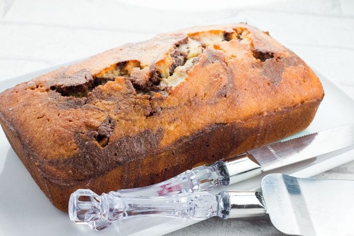 Glazed Marble Poun Cake on a serving platter ready to slice