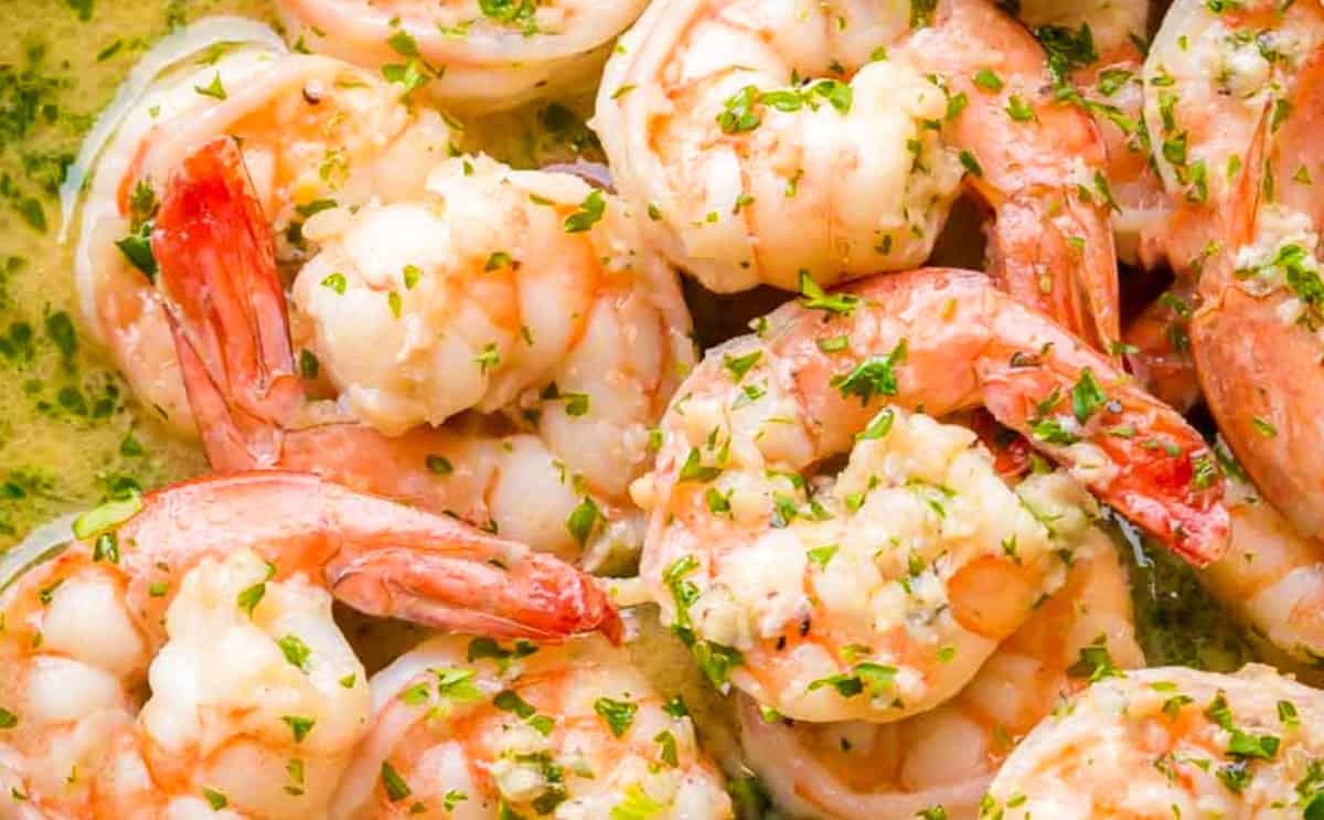 A pan with the shrimp cooking in the scampi sauce