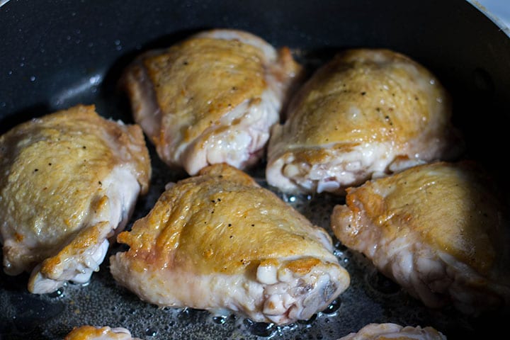 The chicken with the golden skin cooking in the pan 