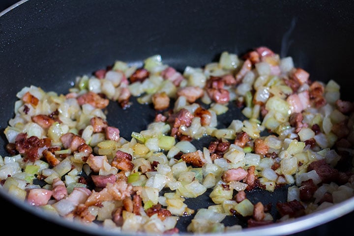 The pan with the onions and bacon cooking