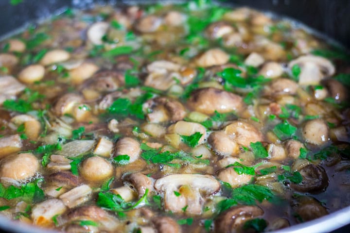 The white wine, stock and parsley added to the pan 