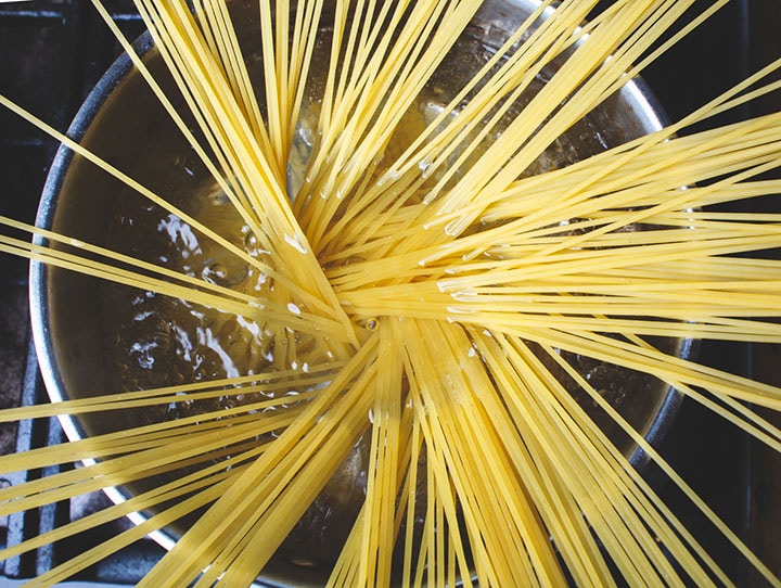 spaghetti pasta is cooking in a pan of boiling water