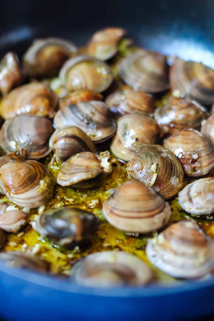 the fresh clams added to the pan with the garlic mixture