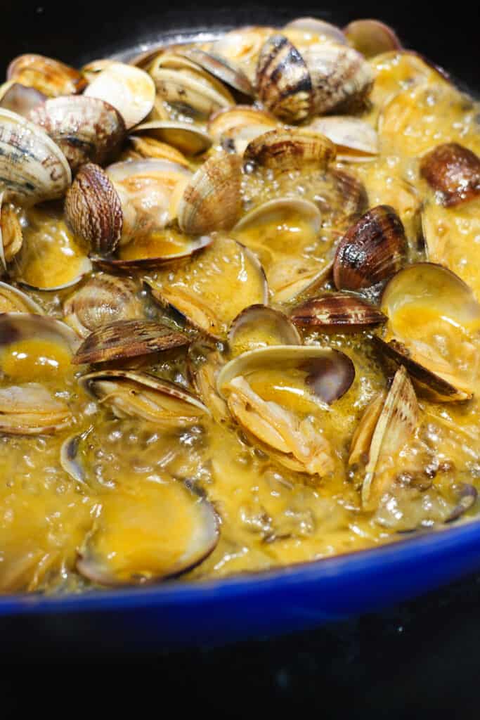 the open clams in the pan with the sauce.