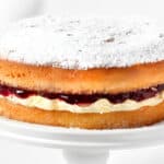 a close up image of a Victoria sponge cake topped with powdered sugar