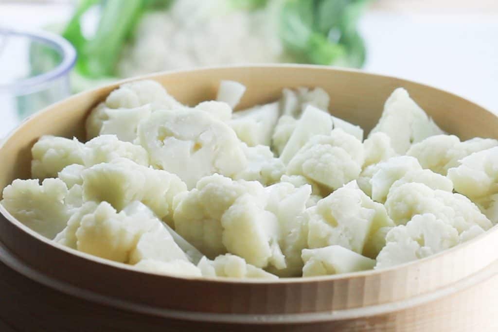 a steamer filled with freshly steamed cauliflower