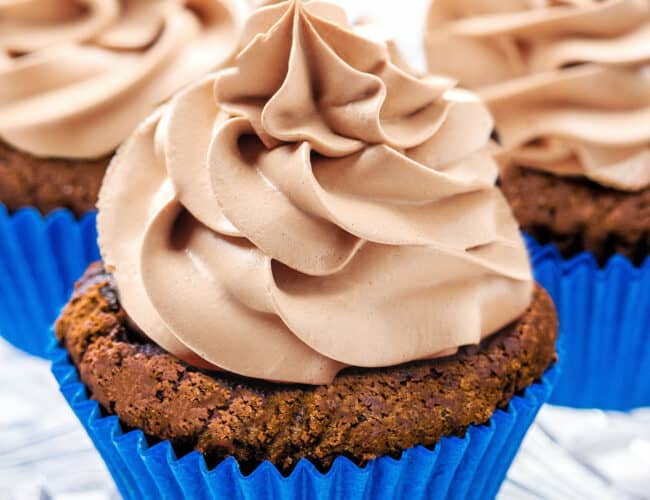 three cupcaked topped with Chocolate Whipped Cream Frosting