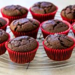 Chocolate cupcakes cooling on a cooling rack.