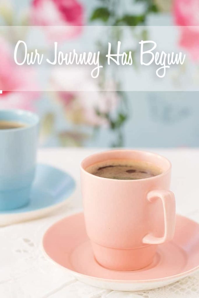 Espresso coffee in pink retro cup and saucer on a lacy white tablecloth against a fresh and floral background.