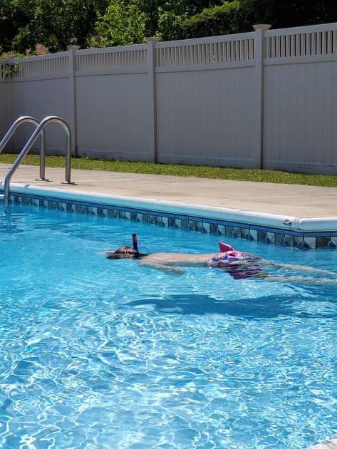 a little boy snorkeling in a swimming pool