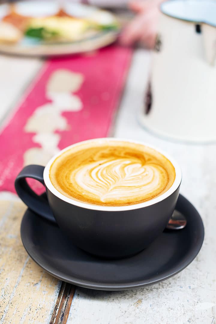 A coffee cup filled with cappuccino on a kitchen table 