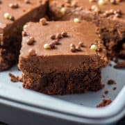 a chocolate fudge sheet cake with a slice cut out of it