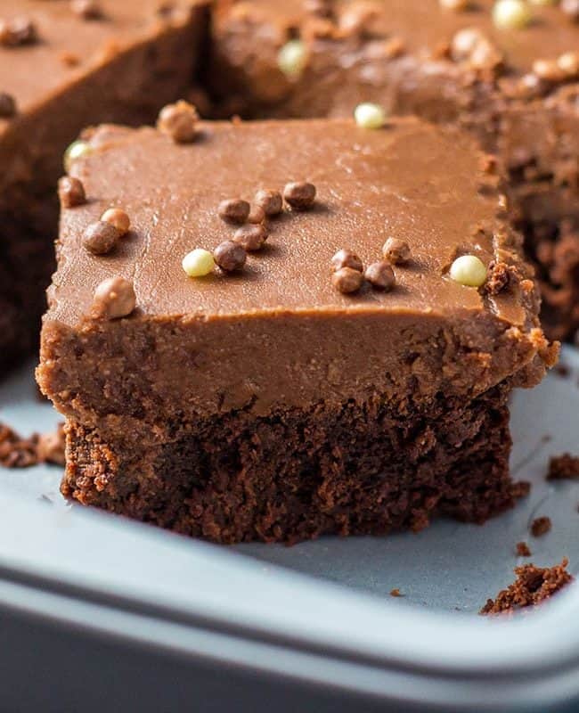 a chocolate fudge sheet cake with a slice cut out of it