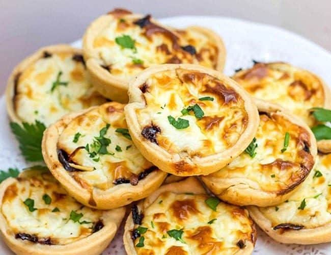 A serving dish piled high with Feta and Caramelized Onion Tarts