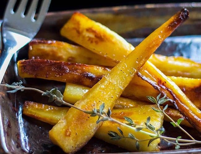 Honey & Maple Roasted Parsnips topped with a sprig of thyme