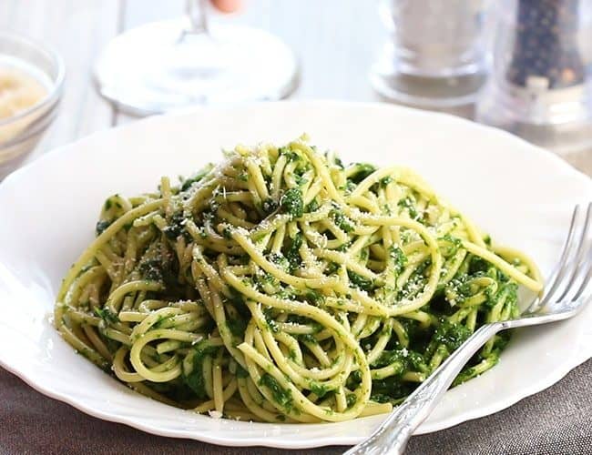 A bowl of Spaghetti with Spinach Sauce with a fork next to it on the plate